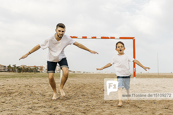 Zwei Fussballspieler feiern ein Tor am Strand
