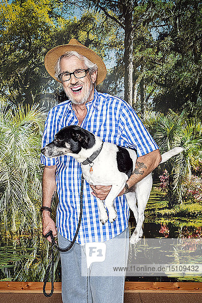 Älterer Mann mit einem Hut und einem Hund  steht vor Fototapete