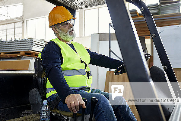 Worker on forklift in factory