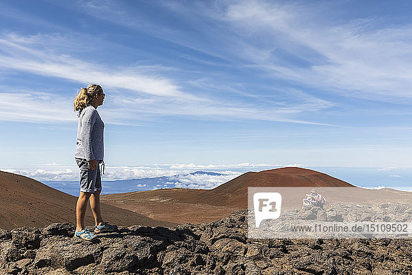 USA  Hawaii  Mauna Kea volcano  female tourist looking at view over volcanic landscape