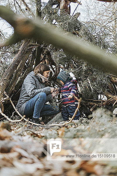 Mutter mit kleiner Tochter in einem Unterstand im Wald