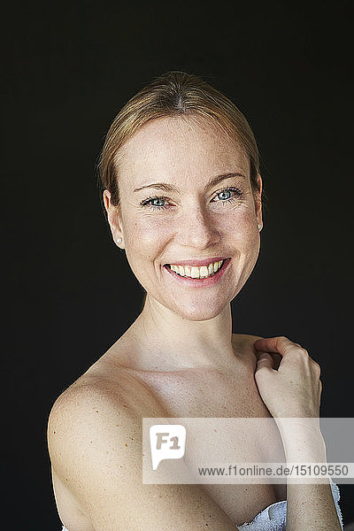 Porträt einer lächelnden Frau  trägerlos  schwarzer Hintergrund