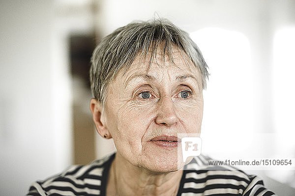Porträt einer älteren Frau mit kurzen Haaren  die wegschaut
