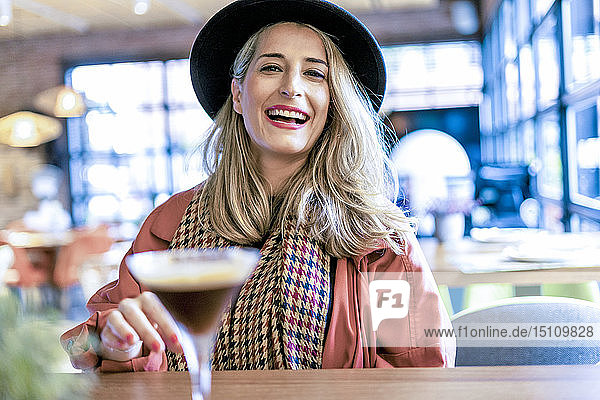 Porträt einer glücklichen Frau bei einem Kaffee-Cocktail in einem Cafe