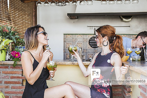 Two women having a drink at a bar