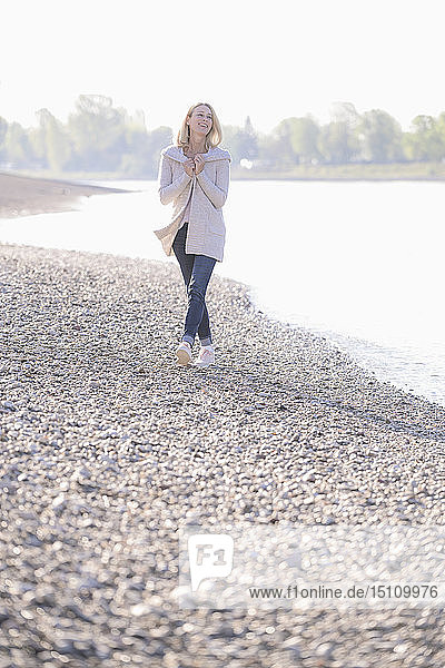 Glückliche reife Frau beim Spaziergang am Flussufer