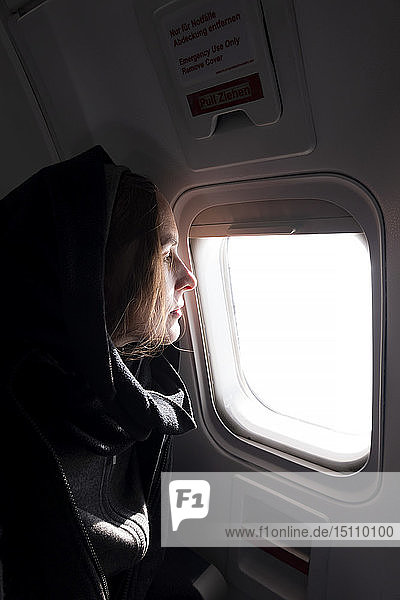 Profil einer Frau im Flugzeug  die aus dem Fenster schaut