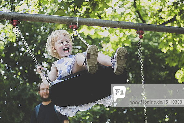 Portrait of happy ltiitle girl on a swing