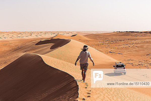 Auf einer Sanddüne gehender Mann  Wahiba Sands  Oman