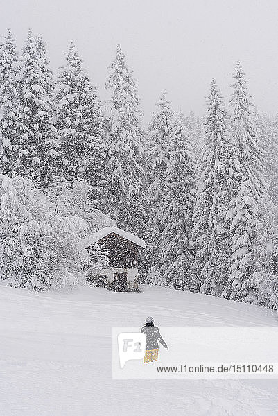 Finnland  Kuopio  Frau wandert bei Schneefall durch die Winterlandschaft