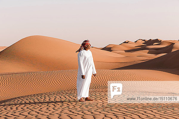 Beduine in Nationaltracht in der Wüste stehend  Wahiba Sands  Oman