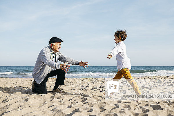 Großvater spielt mit seinem Enkel am Strand