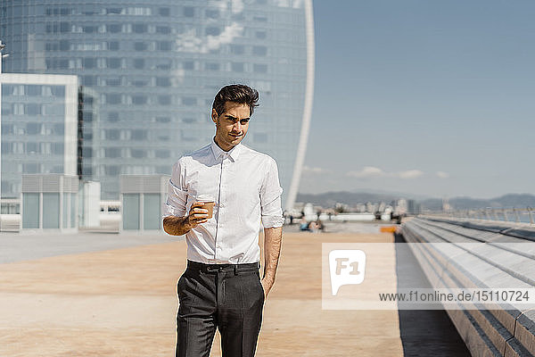 Portrait of businessman with takeaway coffee in the city