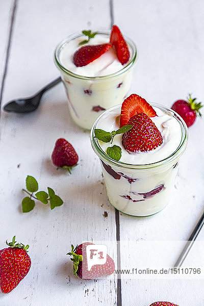 Joghurt mit frischen Erdbeeren und Minze auf Holz
