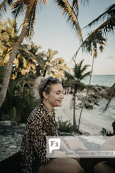 Mexiko  Quintana Roo  Tulum  Porträt einer lächelnden jungen Frau  die sich am Strand entspannt
