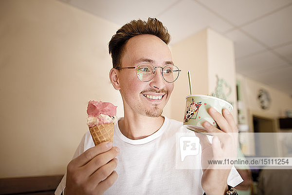 Portrait of young man with ice cream at ice cream parlour