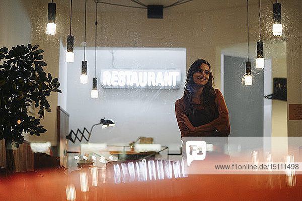 Smiling woman wearing apron standing in a restaurant