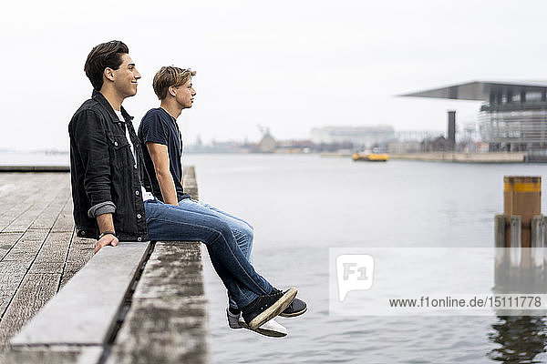 Denmark  Copenhagen  two young men sitting at the waterfront