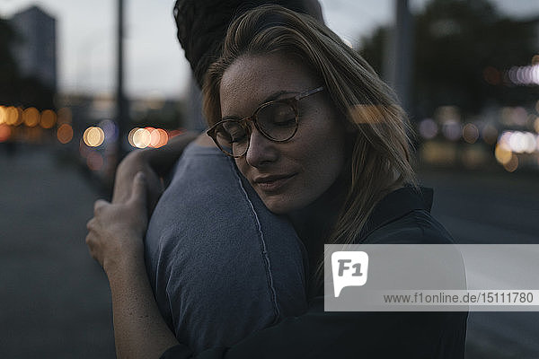 Young couple hugging in the city at dusk