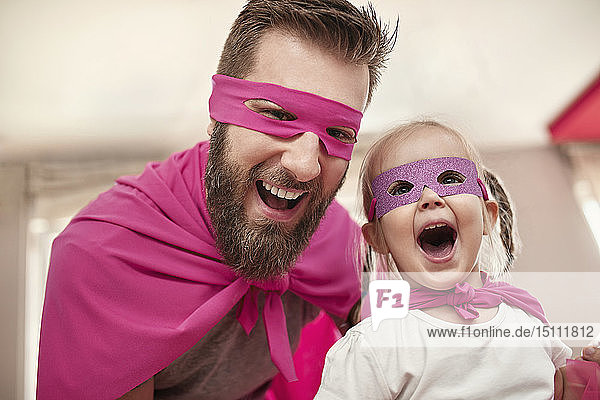 Vater und Tochter spielen Superheldin und Superfrau