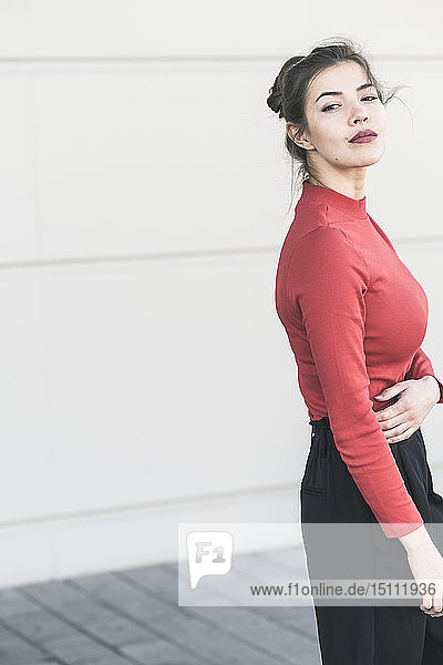 Portrait of elegant young woman at a wall