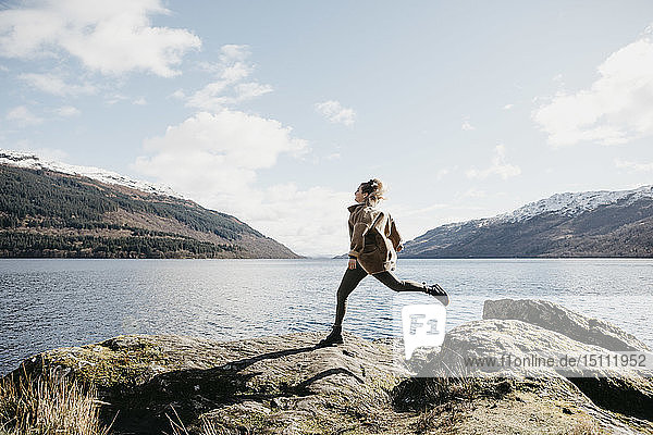 UK Scotland young woman running at Loch Lomond