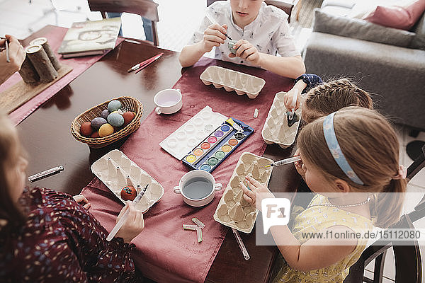 Kinder malen zu Hause Ostereier auf den Tisch