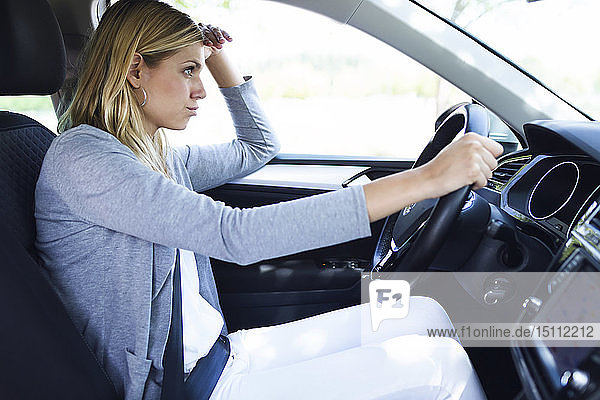 Gestresste junge Geschäftsfrau fährt Auto