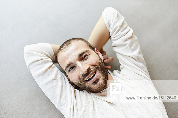 Portrait of happy young man lying on the floor