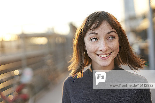 Porträt einer lächelnden jungen Frau in der Abenddämmerung