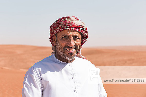 Beduine in Nationaltracht in der Wüste stehend  Porträt  Wahiba Sands  Oman