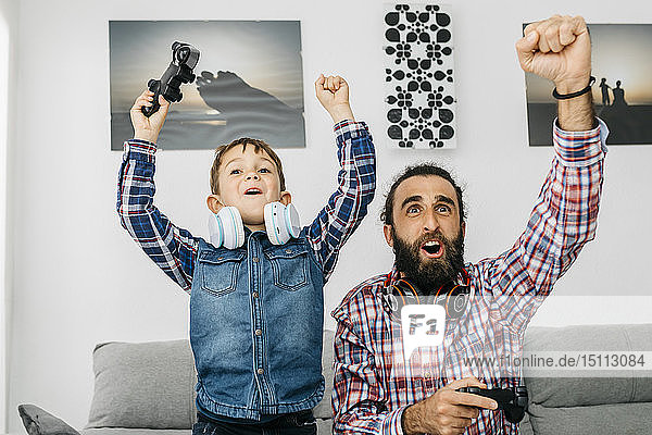 Porträt von Vater und Sohn beim Computerspiel zu Hause