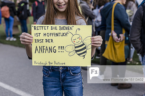 Mädchen hält ein Plakat auf einer Demonstration für Umweltschutz