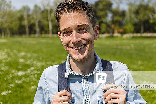 Smiling young man in a park  portrait