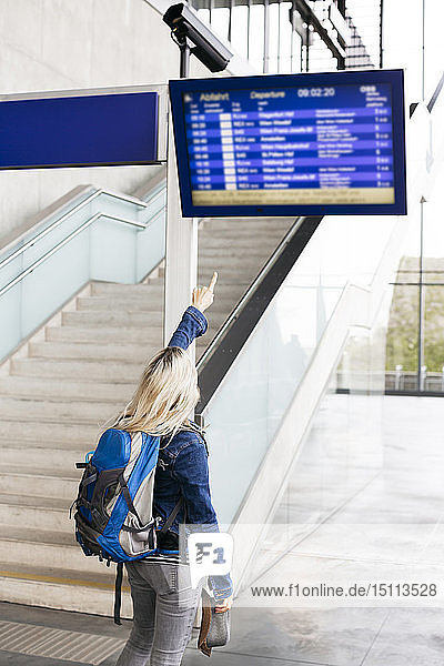 Woman checking the departures board at the station