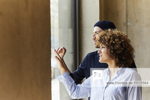 Mann und Frau schauen aus dem Fenster