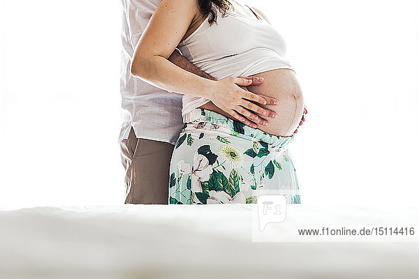 Mann hält Bauch einer schwangeren Frau