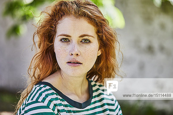Portrait of redheaded young woman with freckles