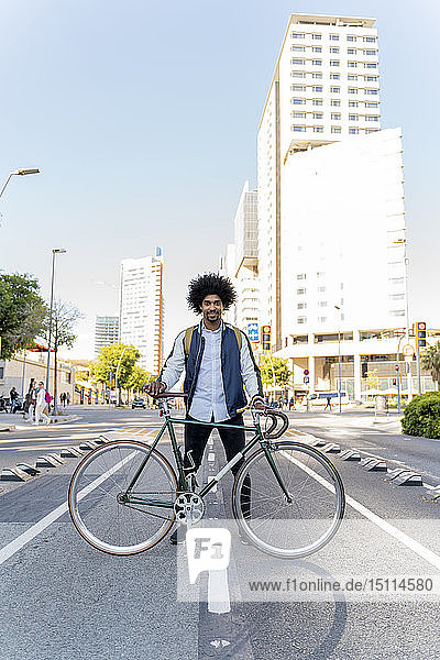 Porträt eines lächelnden Gelegenheits-Geschäftsmannes mit Fahrrad in der Stadt  Barcelona  Spanien
