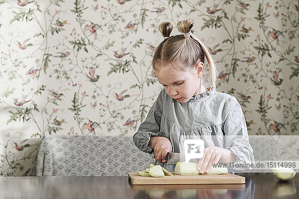 Mädchen schneidet Zucchini in Scheiben