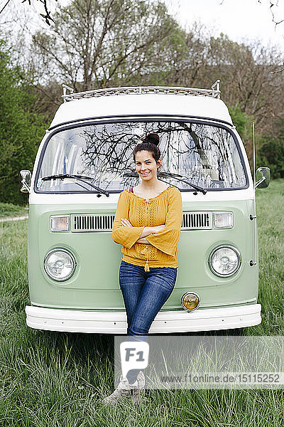 Young woman staniding in front of her camper with arms crossed