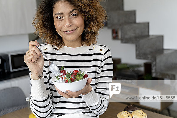 Woman eating strawberries at home