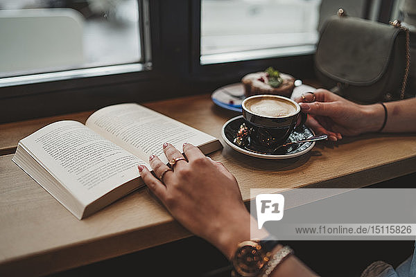 Nahaufnahme einer Frau mit einem Buch in einem Cafe