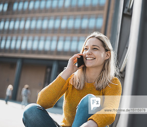 Porträt einer glücklichen jungen Frau am Telefon