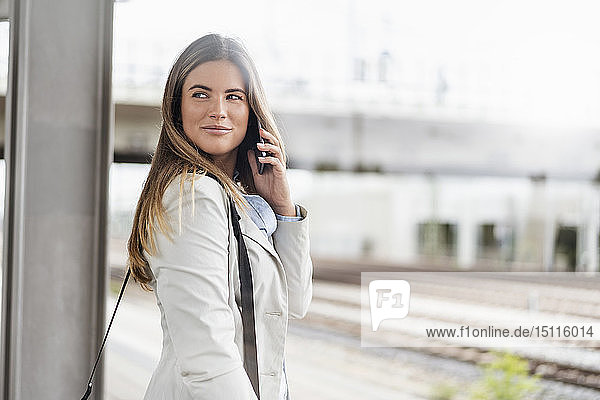 Young businesswoman using smartphone  standing on station