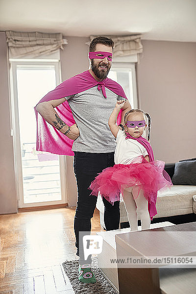 Vater und Tochter spielen Superheldin und Superfrau