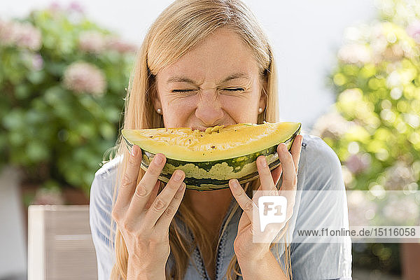 Frau isst Wassermelone im Freien