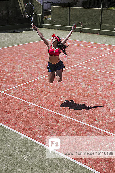Aufgeregte Tennisspielerin jubelt auf dem Platz