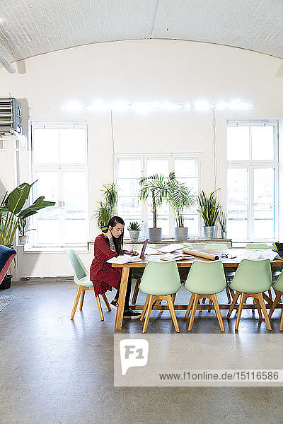 Frau arbeitet am Tisch in einem modernen Büro