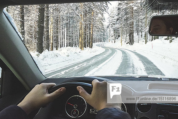 Finnland  Kuopio  Frau fährt Auto in Winterlandschaft
